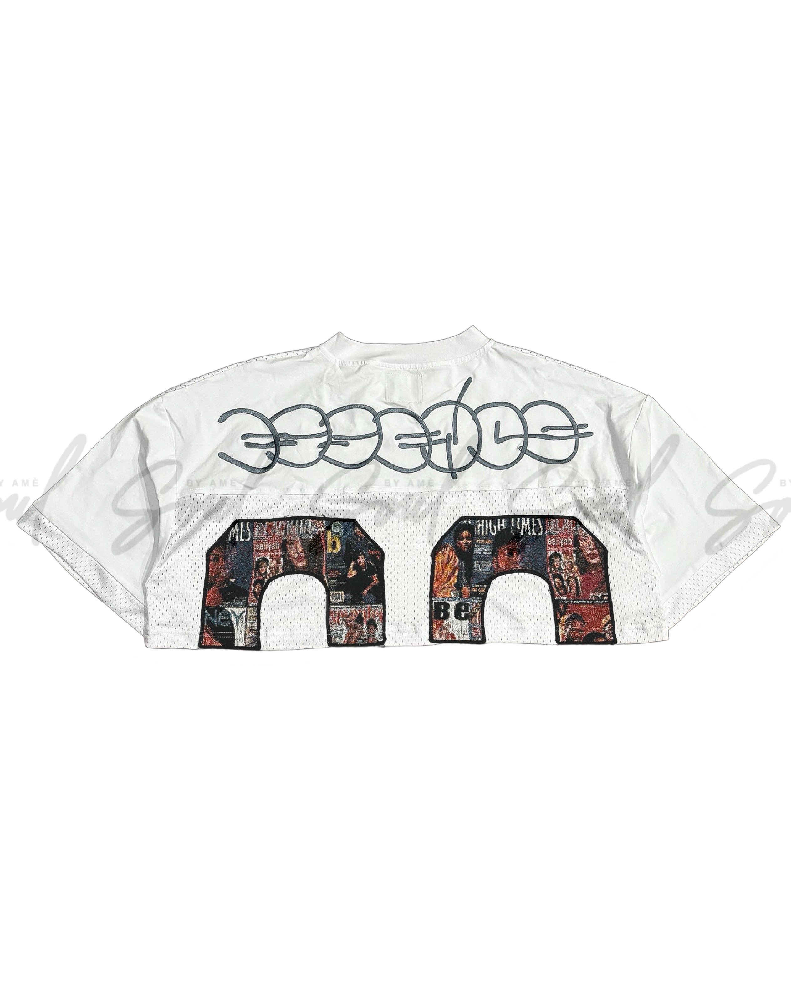 White cropped t-shirt with ’GOOD KIDS’ text and floral-patterned number design.